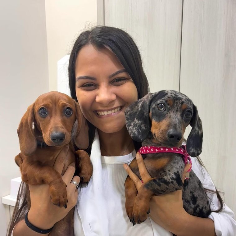 Dra. Isabela com dois cães dachshund no colo